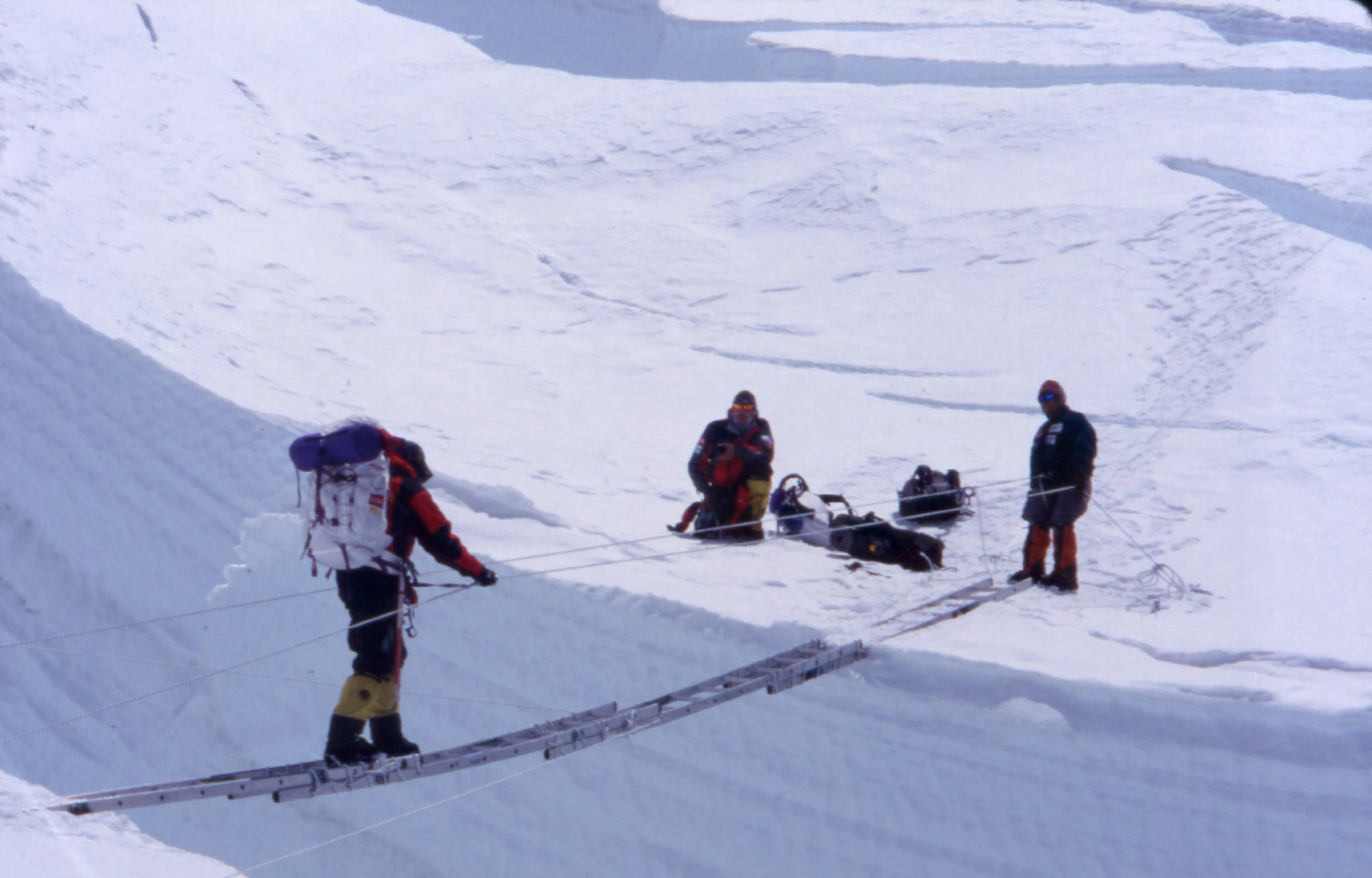 Tom crossing a crevasse bridge on Mount Everest.